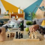Grandfather and grandson playing chess at a table.