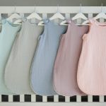 a row of baby swaddles hanging from a crib